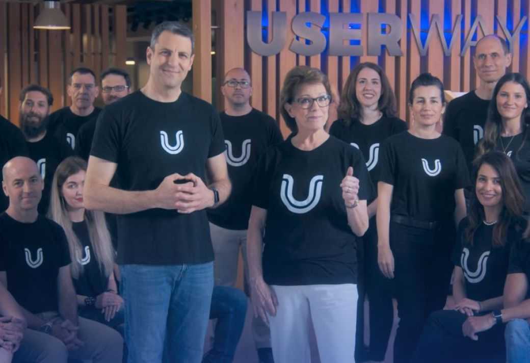 The UserWay team, all wearing T-Shirts with UserWay logos, standing together and smiling