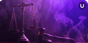 Scales of Justice on the left of the image and a gavel and sound block on the right sit on a desk before a room obscured in smoke