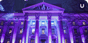 A New Jersey courthouse with the building outlined in bright purple and blue lights in the windows