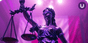 A statue of Lady Justice and her scales stands in front of a draped cloth background in pink with ceiling lights shining above her head