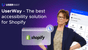 A woman is standing next to a presentation that says "UserWay - The best accessibility solution for Shopify." There is an image of a computer screen displaying the Shopify logo and an accessibility interface with various options like "Screen Reader" and "Contrast +" indicating UserWay's services. The UserWay logo is displayed in the top left corner.