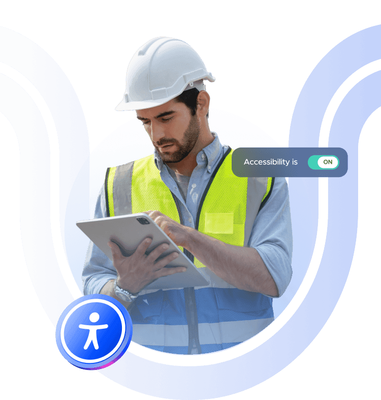 A white man wearing a hard hat and using a tablet