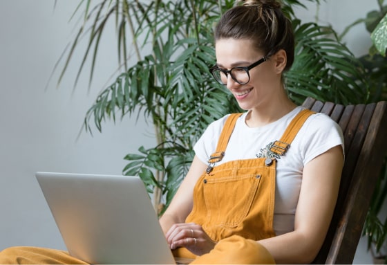 Woman in yellow jumper using laptop